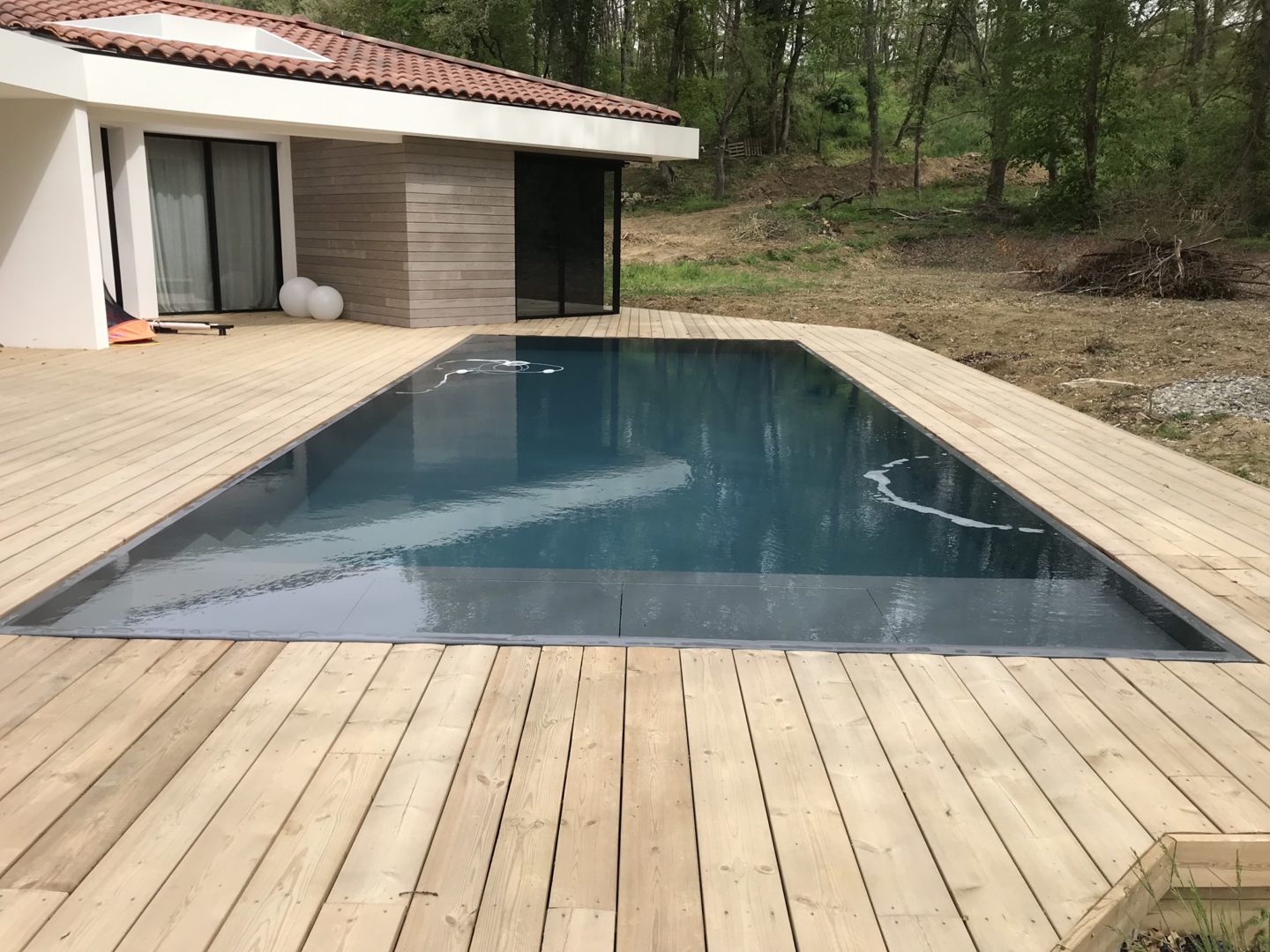 Piscine miroir 10 x 4 – Terrasse bois – Volet roulant immergé – Lyneo